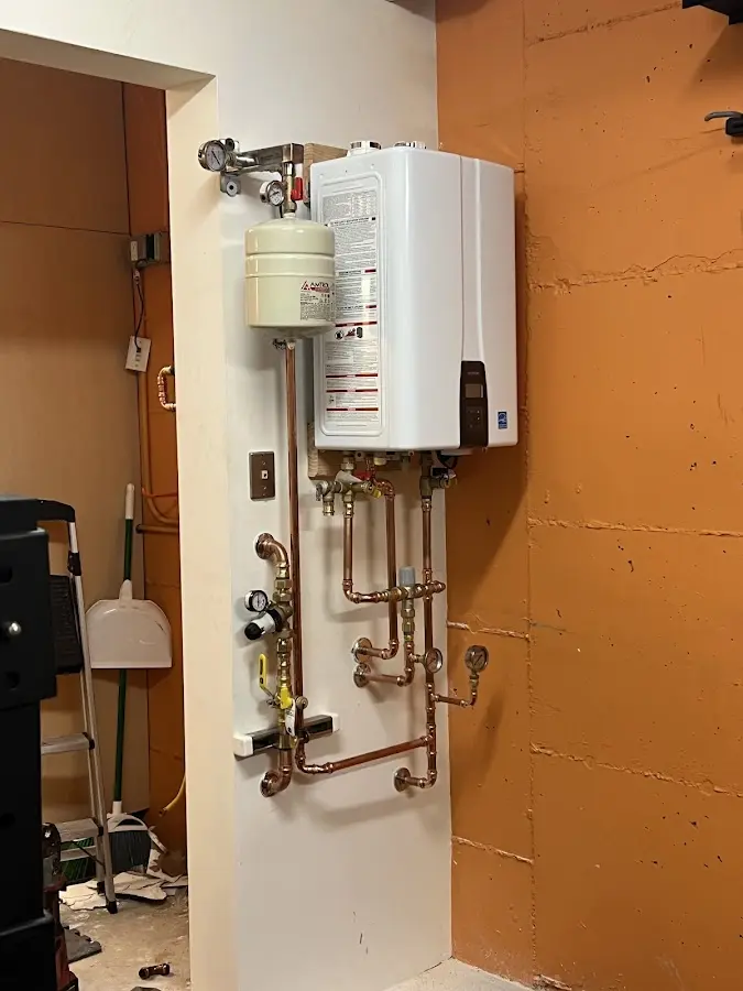 Plumbing technician inspecting water heater connections in Cramerton